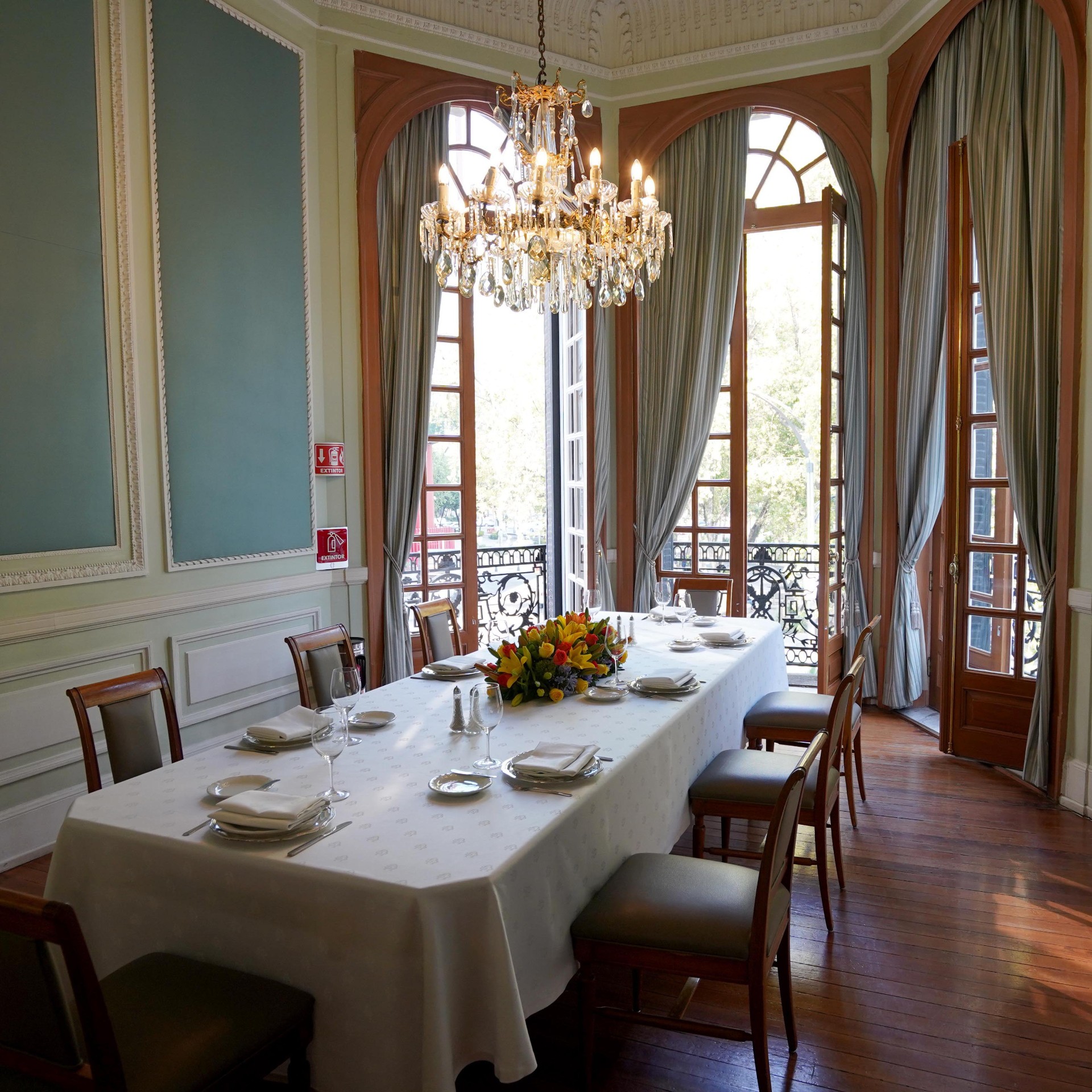 Salón Reforma at The University Club, sage-green walls and crystal chandelier